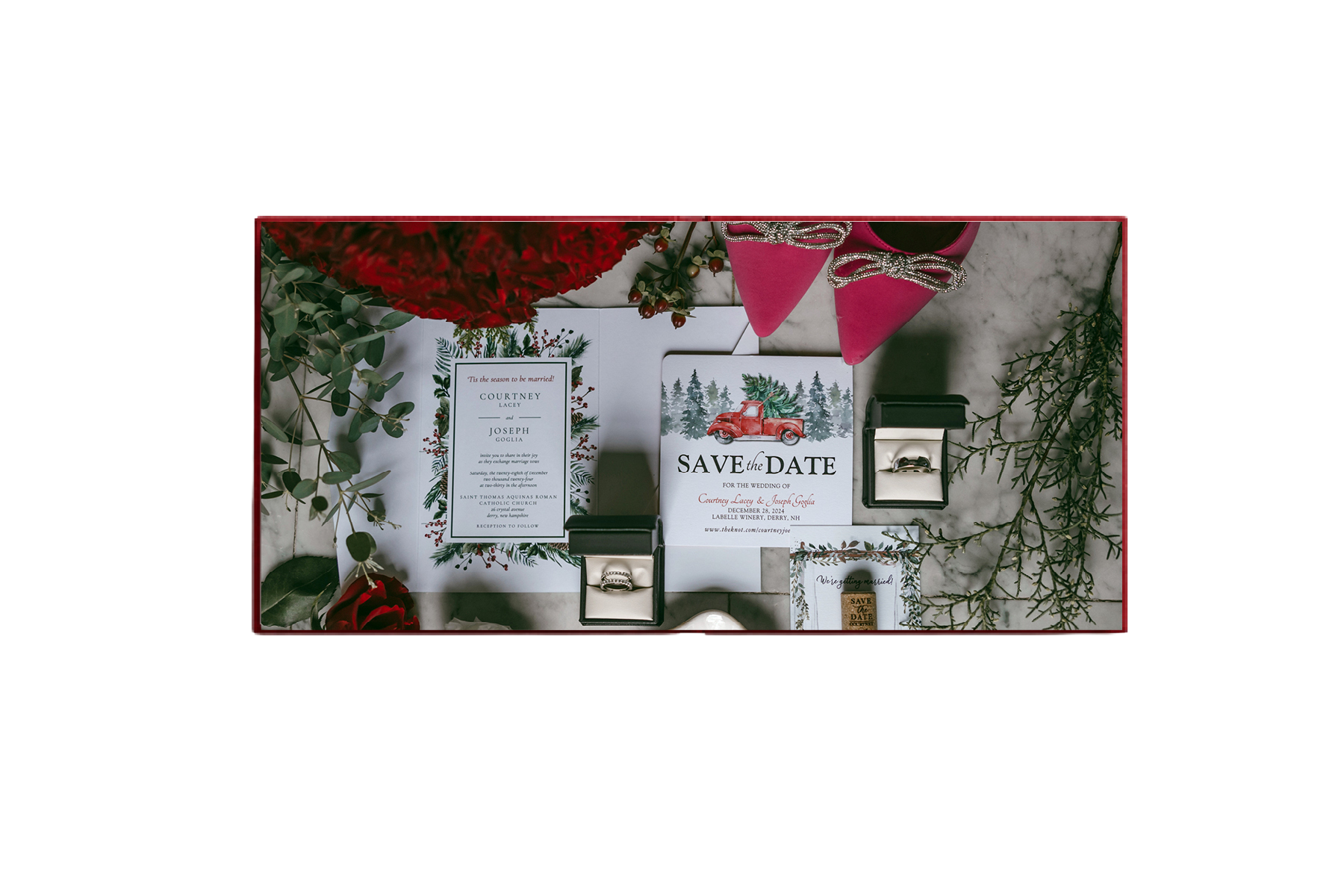 Open wedding album spread showing invitation suite, rings and florals